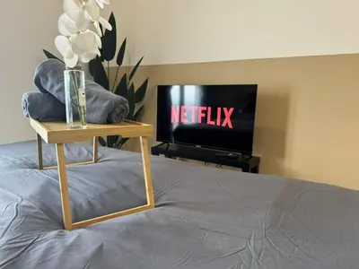 a bed with a vase of flowers and a television at Trion KL, Jalan Chan Sow Lin, Kuala Lumpur by One Guesthouse in Kuala Lumpur