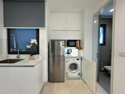 a kitchen with a refrigerator and a washing machine at Lucentia Apartments in Kuala Lumpur