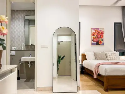 a bedroom with a mirror next to a bed at Lucentia Apartments in Kuala Lumpur