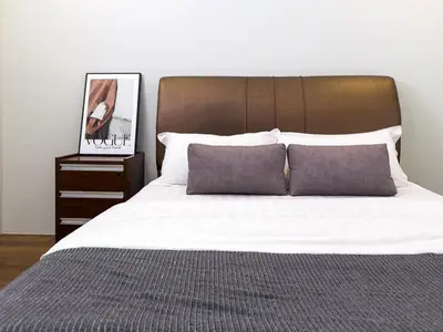 a bedroom with a white bed with a wooden headboard at Sky Suites KLCC Premium Stay in Kuala Lumpur