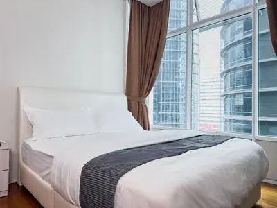a bed in a room with a large window at Sky Suites KLCC Premium Stay in Kuala Lumpur