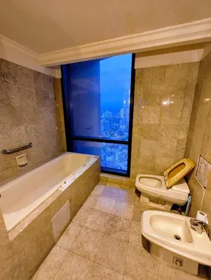 a bathroom with a tub and a toilet and a window at Services Star Hotel Suites At Times Square in Kuala Lumpur