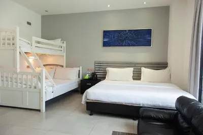 a bedroom with two bunk beds and a couch at M Design Hotel @ Shamelin Perkasa in Kuala Lumpur