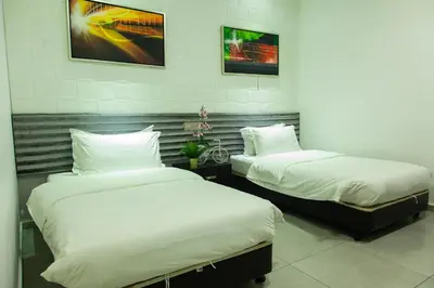 two beds in a room with white sheets at M Design Hotel @ Shamelin Perkasa in Kuala Lumpur