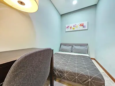 a bedroom with a bed and a table and chairs at The Sky Suites KLCC by the Park in Kuala Lumpur