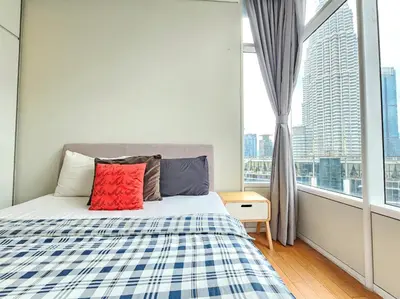 a bedroom with a bed and a large window at The Sky Suites KLCC by the Park in Kuala Lumpur
