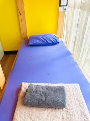a bed in a room with a pillow on it at Regalia Skypool KLCC Friendly Hostel in Kuala Lumpur