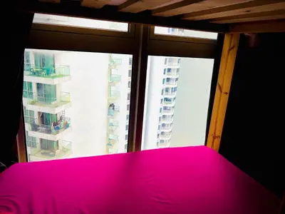 a bedroom with a pink bed in front of a window at Regalia Skypool KLCC Friendly Hostel in Kuala Lumpur