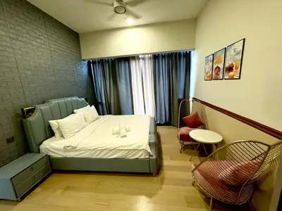 a hotel room with a bed and a table and chairs at The KLCC At Star SKY Pools in Kuala Lumpur
