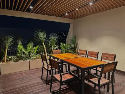 a wooden table and chairs on a deck with plants at KLCC View Datum Jelatek Escape by Filux Holiday in Kampong Datok Keramat