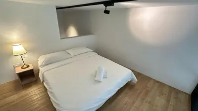 a bedroom with a bed with white sheets and a lamp at The Establishment Bangsar #19 by Ouki in Kuala Lumpur