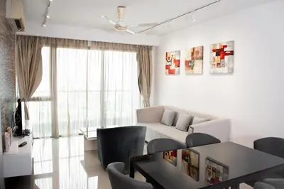 a living room with a couch and a table and chairs at MyHabitat Residences in Kuala Lumpur