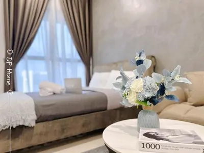 a bedroom with a bed and a table with a vase of flowers at Studio KL Trion for 2-3 pax KL TRX Velocity in Kuala Lumpur