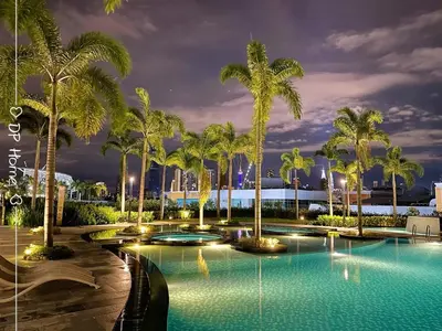 a pool with palm trees at night at Studio KL Trion for 2-3 pax KL TRX Velocity in Kuala Lumpur