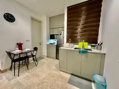 a kitchen with a sink and a table with chairs at Stylish Apartment at Lucentia residence BBCC Lalaport in Kuala Lumpur