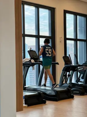 a man walking on a treadmill in a gym at The BirdsEye View facing KLCC with Gorgeous pools in Kuala Lumpur
