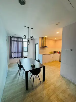 a living room with a table and chairs and a kitchen at Taragon Standard Homestay in Kuala Lumpur