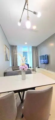 a living room with a table with chairs and a couch at Sky Suites KLCC host by REST Corner Suites in Kuala Lumpur