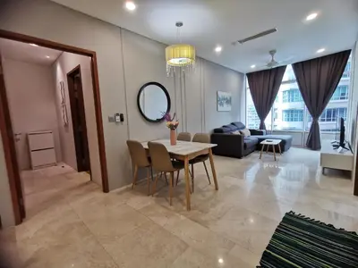 a living room with a table and a couch at Sky Suites KLCC host by REST Corner Suites in Kuala Lumpur