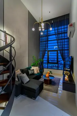 a living room with a black couch and a staircase at Novo Ampang, Luxury Premium 3BR Penthouse, Kuala Lumpur by Cobnb in Kuala Lumpur