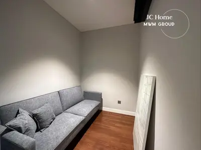 a living room with a gray couch in a room at The Anggun l 5-star Bathtub Suites By MWM in Kuala Lumpur