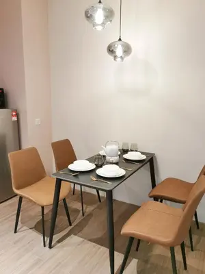 a black table with chairs and plates on it at Weekly Monthly Stay - Bangsar Trade Centre Curvena in Kuala Lumpur