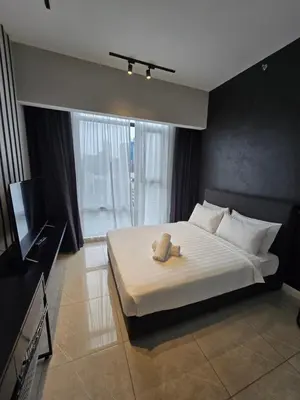 a bedroom with a bed with a teddy bear on it at AXON Bukit Bintang Suites KL in Kuala Lumpur