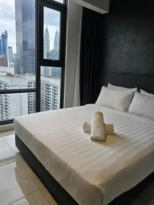 a bedroom with a large bed with a large window at AXON Bukit Bintang Suites KL in Kuala Lumpur