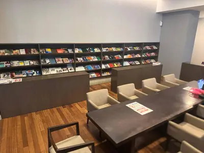 a room with a table and chairs and books at KL Infinity Luxury Skypool hostel in Kuala Lumpur