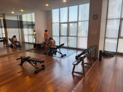 a gym with two children sitting on benches in a room with windows at KL Infinity Luxury Skypool hostel in Kuala Lumpur