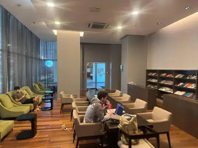 a group of people sitting in a waiting room with a laptop at KL Infinity Luxury Skypool hostel in Kuala Lumpur