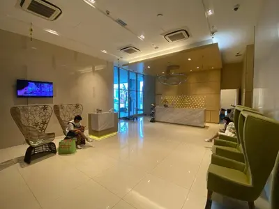 a lobby with people sitting in chairs in a building at KL Infinity Luxury Skypool hostel in Kuala Lumpur