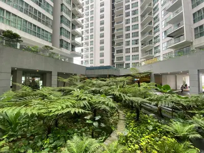 a garden in the middle of a building with tall buildings at Infinity Skypool hostel in Kuala Lumpur
