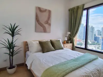 a bedroom with a bed with a plant and a window at Lucentia Residence, Bukit Bintang City Centre in Kuala Lumpur