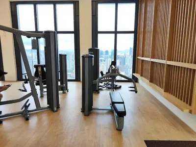 a gym with tread machines in a room with windows at Lucentia Residence, Bukit Bintang City Centre in Kuala Lumpur