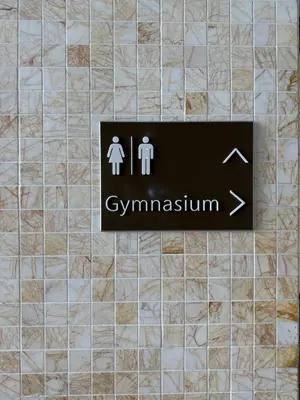 a sign on a tile wall with a man and a woman at The Platinum Kuala Lumpur by Skyscraper in Kuala Lumpur
