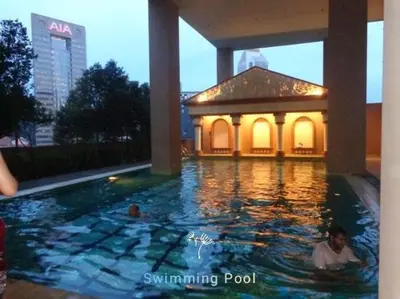 a man swimming in a swimming pool with a gazebo at Maytower Studio in Kuala Lumpur