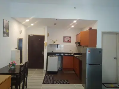 a small kitchen with a refrigerator and a table at Maytower Studio in Kuala Lumpur