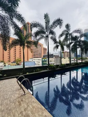 a swimming pool with palm trees in a city at Residence HomeStay in Kuala Lumpur