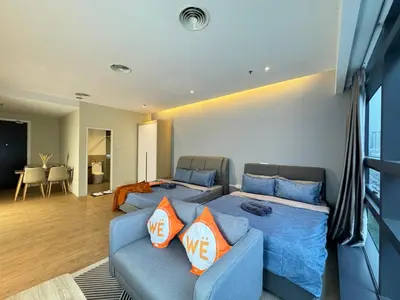 a living room with a blue couch with orange pillows at Weekly Monthly Stay - Bangsar Trade Centre Benton in Kuala Lumpur