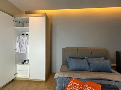a bedroom with a bed with blue pillows and a closet at Weekly Monthly Stay - Bangsar Trade Centre Benton in Kuala Lumpur