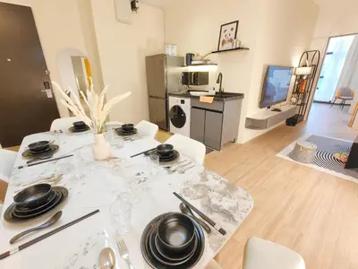 a living room with a table with plates and utensils at Weekly Monthly Stay - Bangsar Trade Centre Aspire in Kuala Lumpur