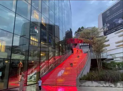 a red staircase in front of a glass building at BEST 4-5pax KL Amazing View SkyPool Bukit Bintang in Kuala Lumpur
