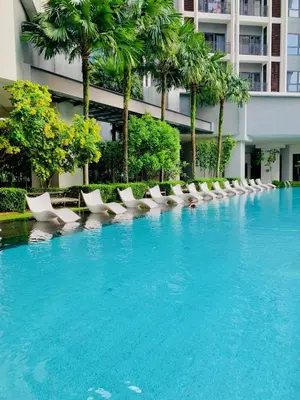 a swimming pool with white lounge chairs and palm trees at The MEWS KLCC By Arman in Kuala Lumpur