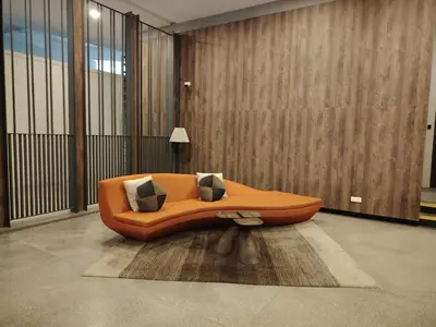 an orange couch with pillows on a rug in a room at The MEWS KLCC By Arman in Kuala Lumpur