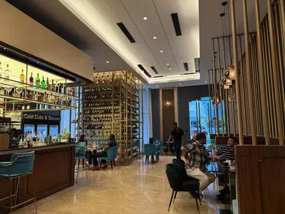a restaurant with a bar and people sitting at tables at The MEWS KLCC By Arman in Kuala Lumpur