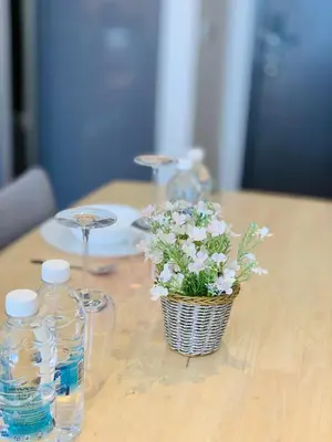 a table with two bottles of water and a basket of flowers at The Mews KLCC By SKY GARDEN in Kuala Lumpur