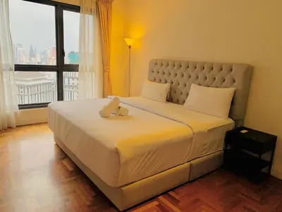 a bedroom with a large bed with a large window at The Mews KLCC By SKY GARDEN in Kuala Lumpur