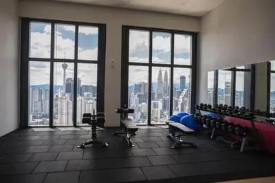 a gym with a view of a city skyline at Lucentia Residences by Luxe Suites in Bukit Bintang KLCC! in Kuala Lumpur