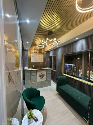 a lobby with a green couch and a counter at SS GREY INN Jalan bukit bintang in Kuala Lumpur
